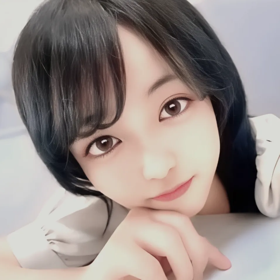 黒いショートボブの髪型で、テーブルに肘をつき、手にあごを乗せてこちらを見つめている女性、ハズキさん。