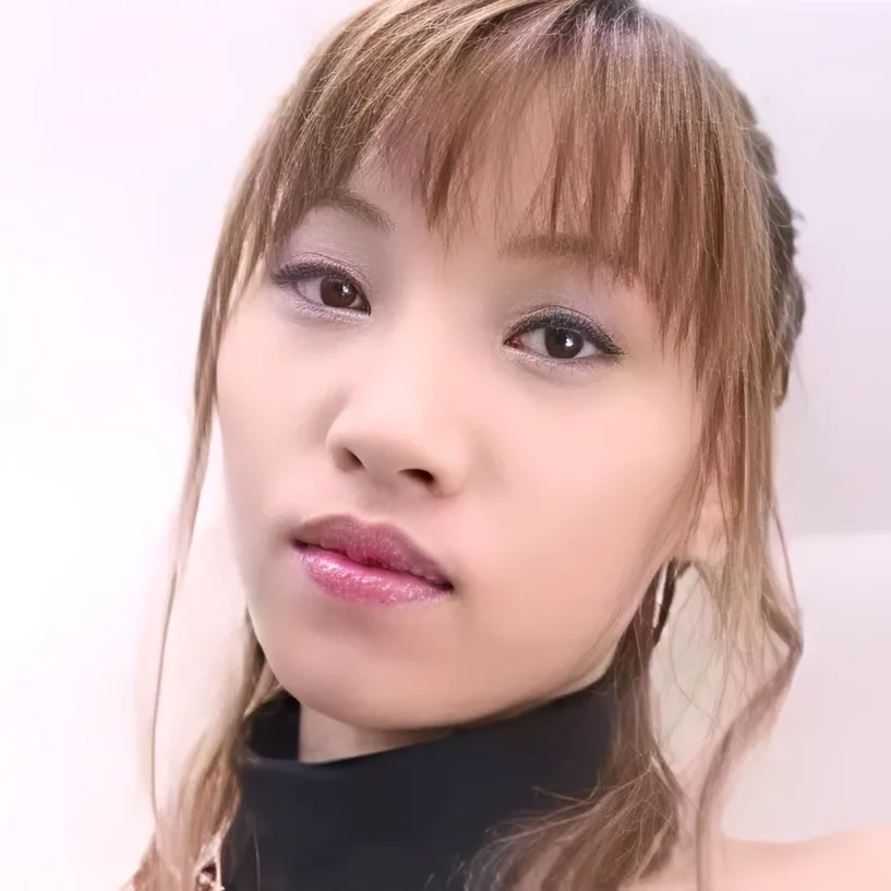 黒いタートルネックの服を着て、こちらを見つめている、ハイライトの入った茶髪の女性、星野真弥さん。