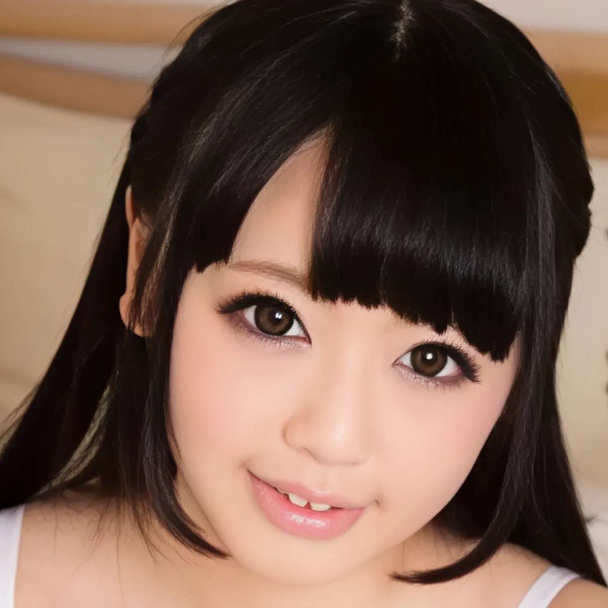 姫カットの黒髪ロングヘアーで、白いタンクトップを着てこちらを見つめ、少し微笑んでいる女性、辻井ゆうさん