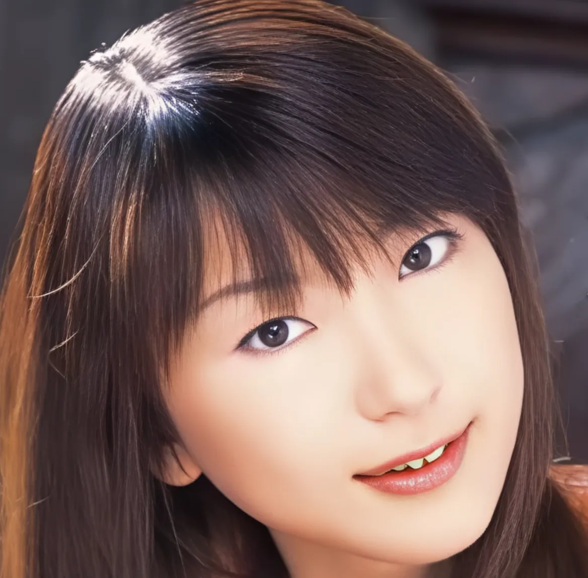 茶色いロングヘアーで前髪があり、こちらに優しく微笑みかけている女性、堤さやかさん。